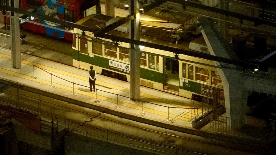 夜晚车站站台停靠的列车与乘客