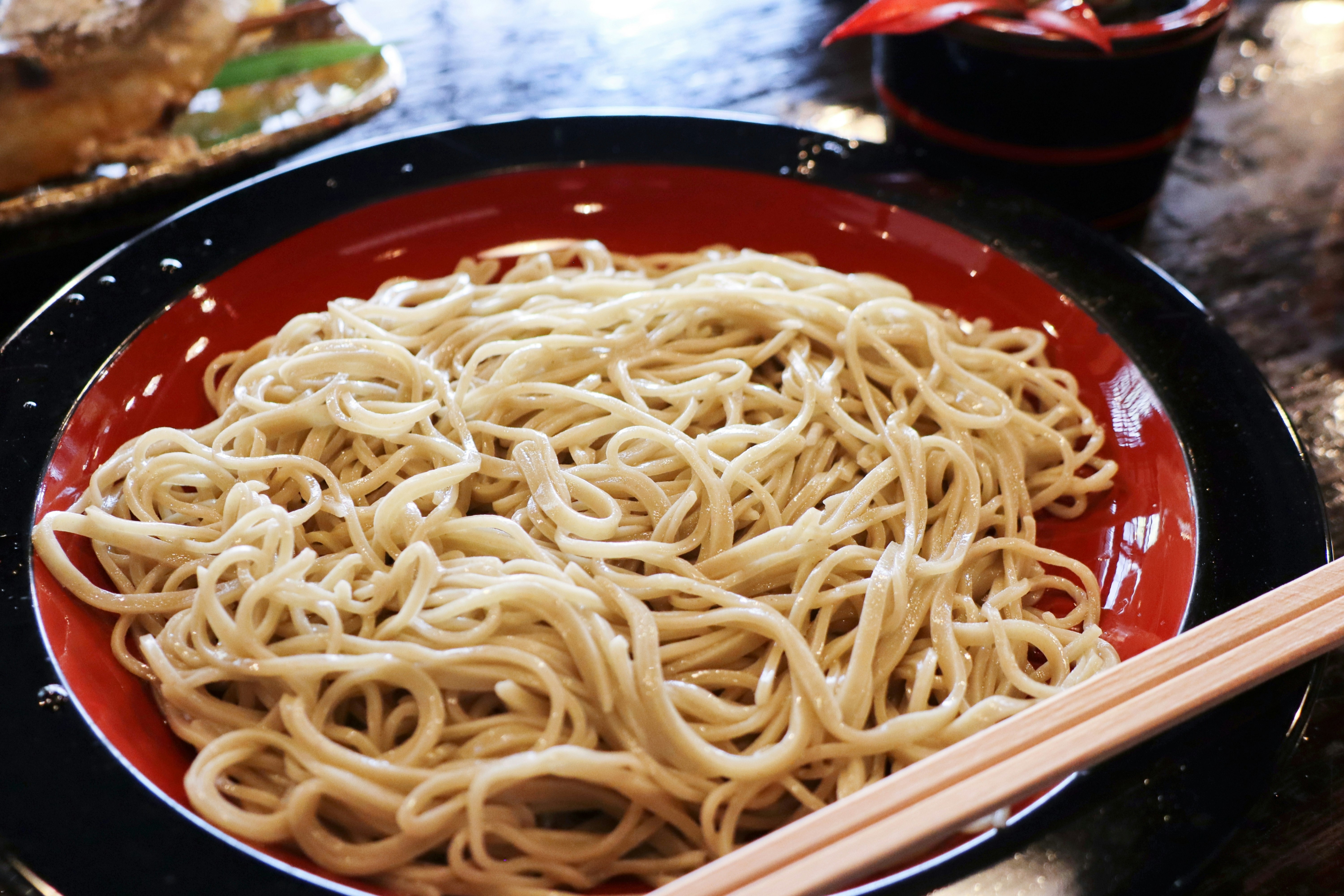 紅色碗裡的ざるそば麵與筷子特寫
