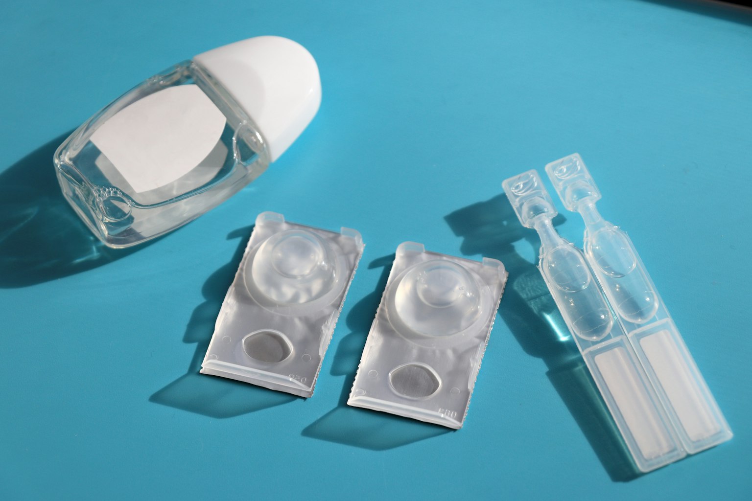 Hộp kính áp tròng và kính trên nền xanh