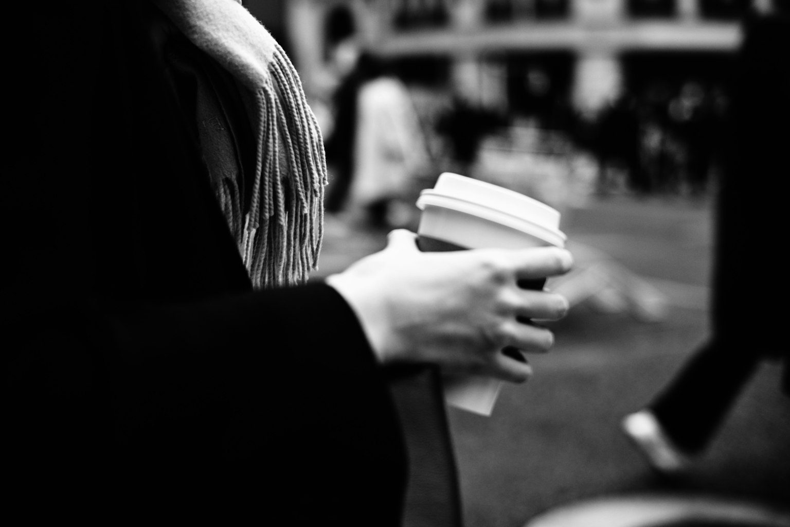 Foto in bianco e nero di una mano femminile che tiene una tazza di caffè