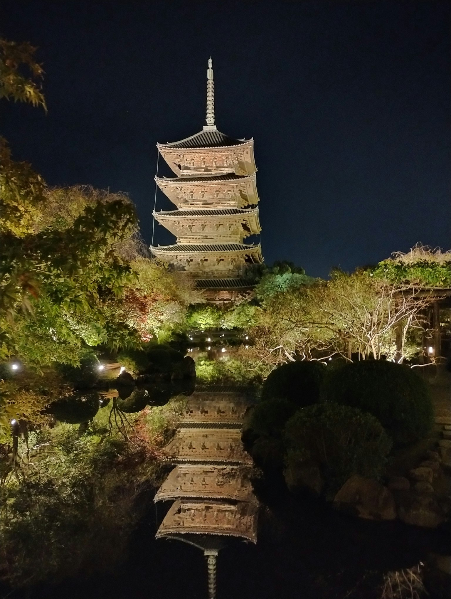 Pemandangan indah pagoda yang memantul di kolam saat malam