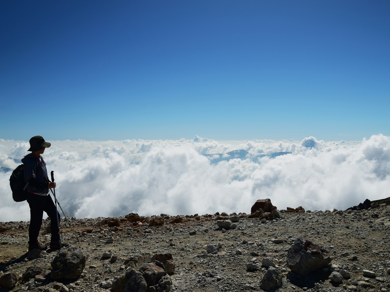 Pendaki yang mengawasi lautan awan dari puncak gunung