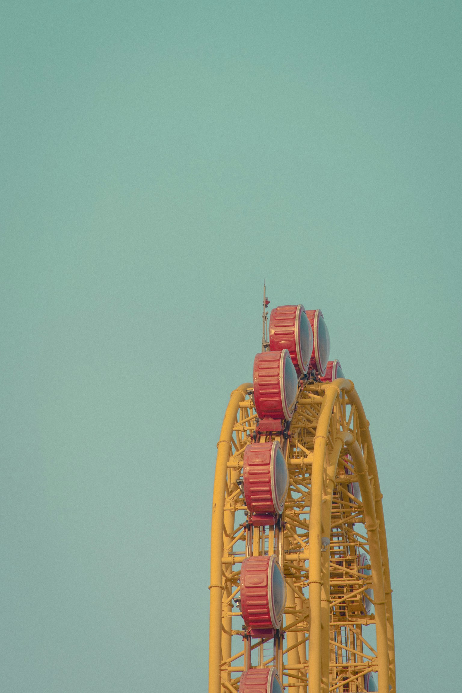Partie d'une grande roue de la fortune contre un ciel bleu avec un cadre jaune et des cabines rouges