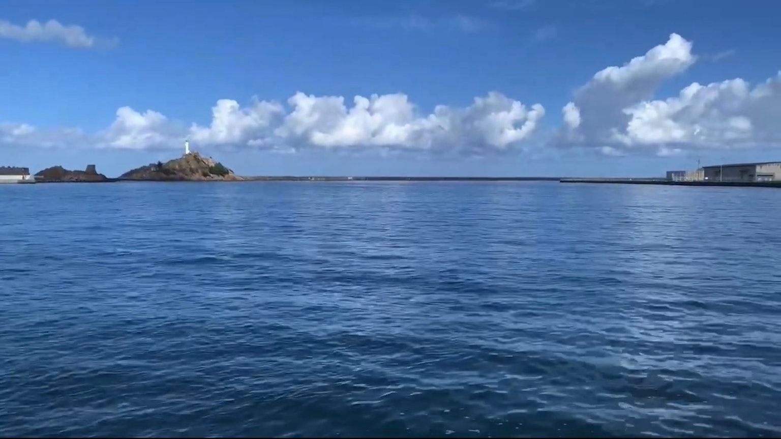 在蓝天和宁静海洋下的小岛和灯塔的风景