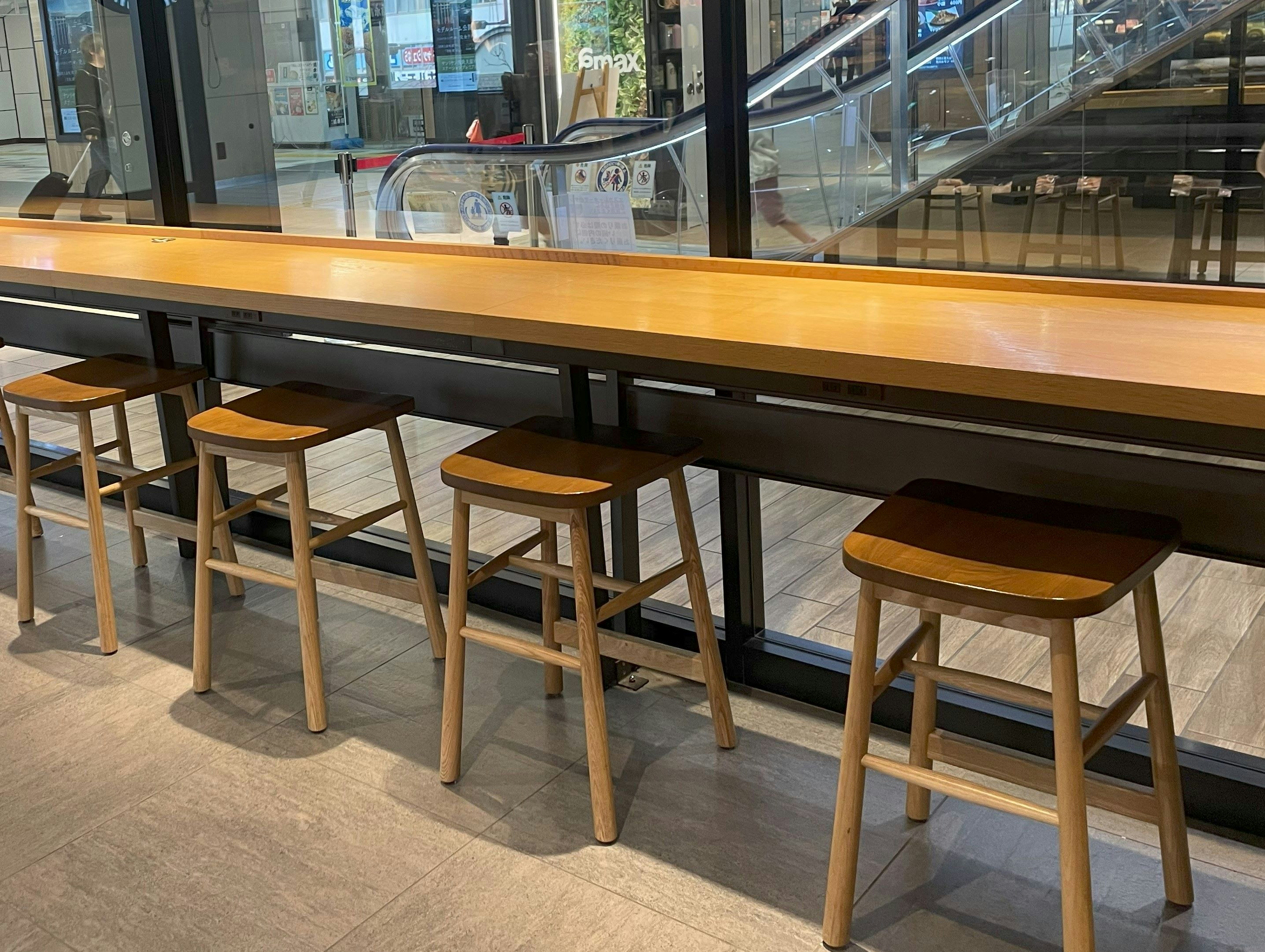 Cafe interior with rows of wooden stools and tables