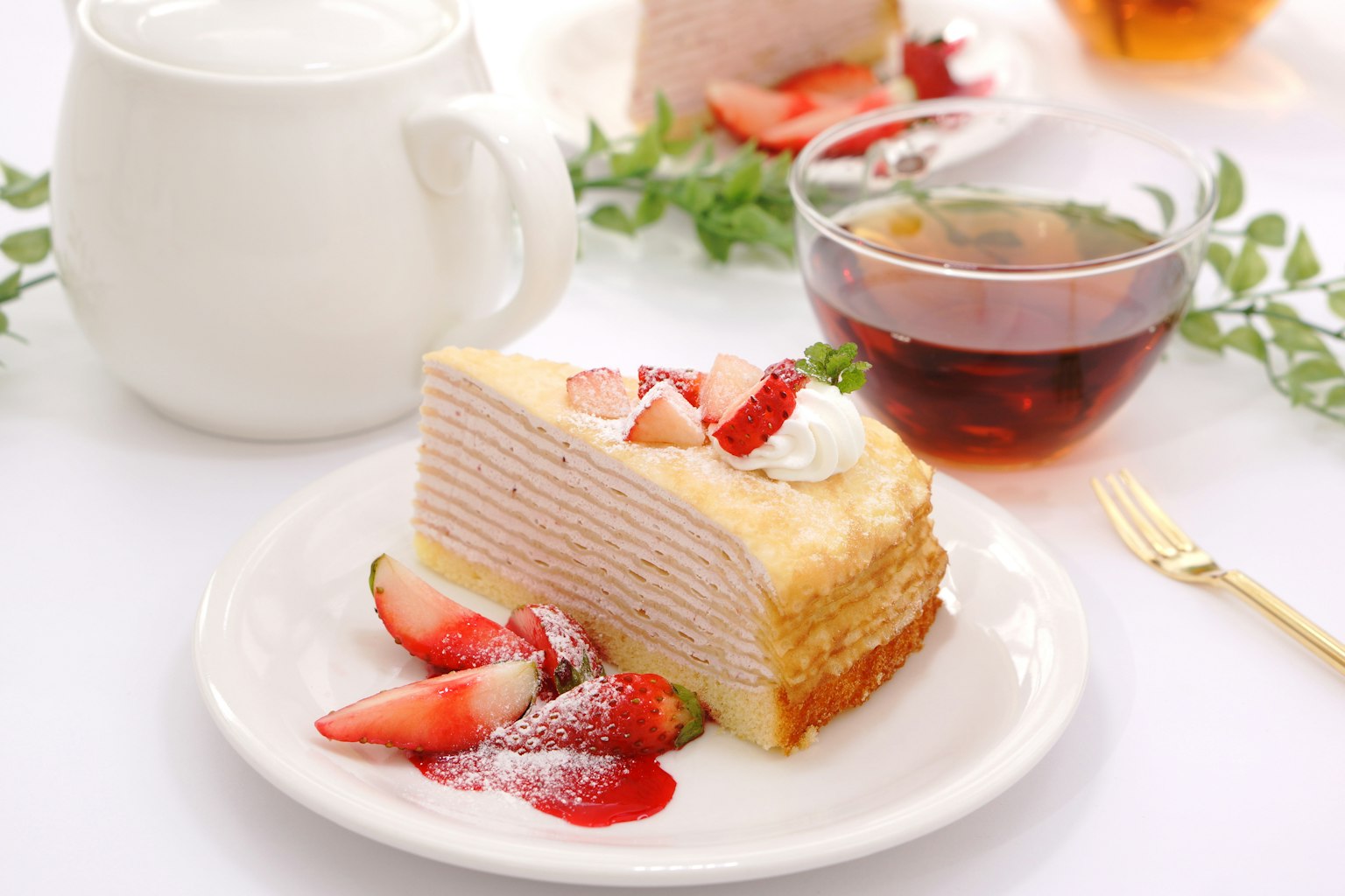 Slice of strawberry cake with a cup of tea and fresh strawberries