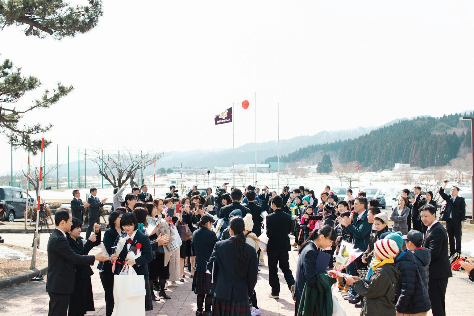 꽃다발을 들고 있는 사람들의 그룹이 아름다운 야외 환경에서 모여 있다