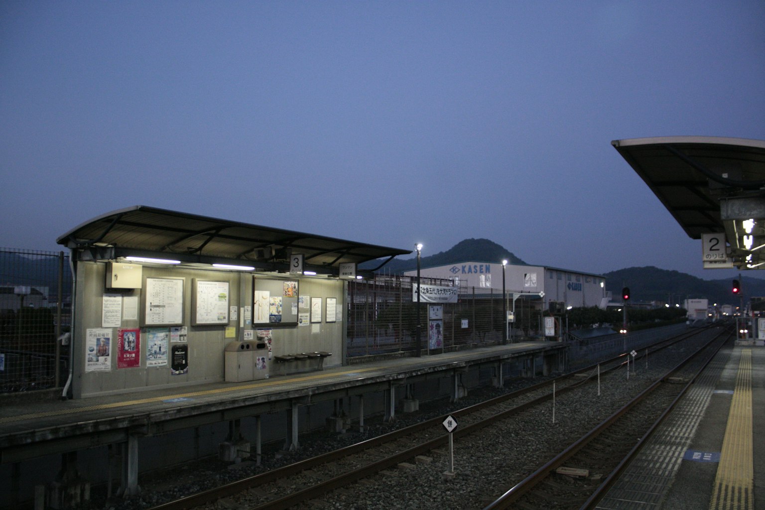 Plateforme de train tranquille avec bâtiments au crépuscule