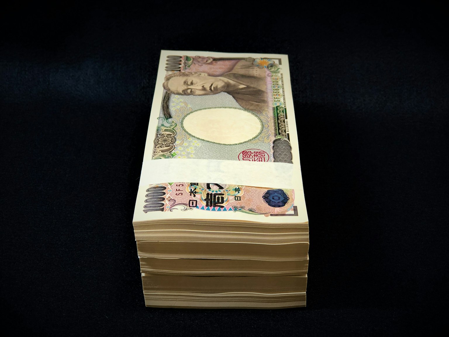 Une pile de billets en yen japonais sur un fond noir