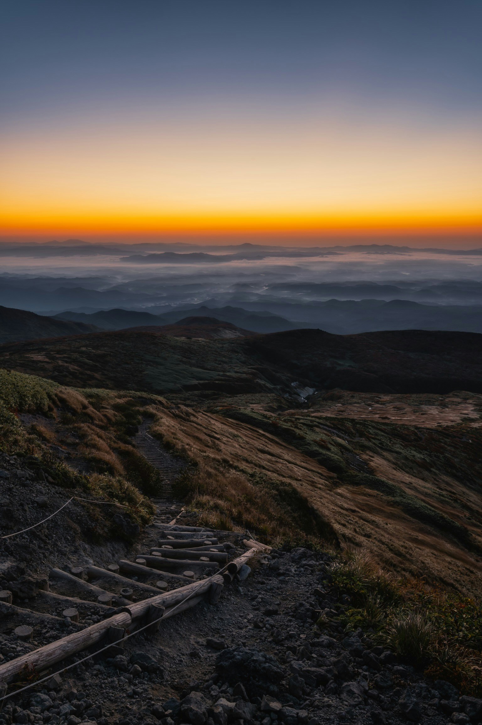 Paesaggio montano al tramonto con un mare di nuvole
