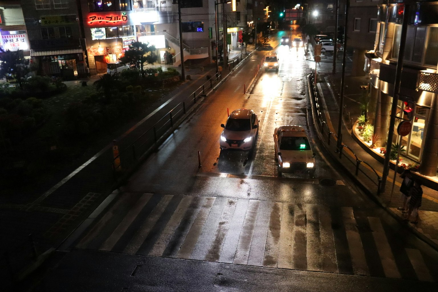 รถยนต์ข้ามทางม้าลายในเมืองยามค่ำคืนที่มีไฟถนนสว่าง