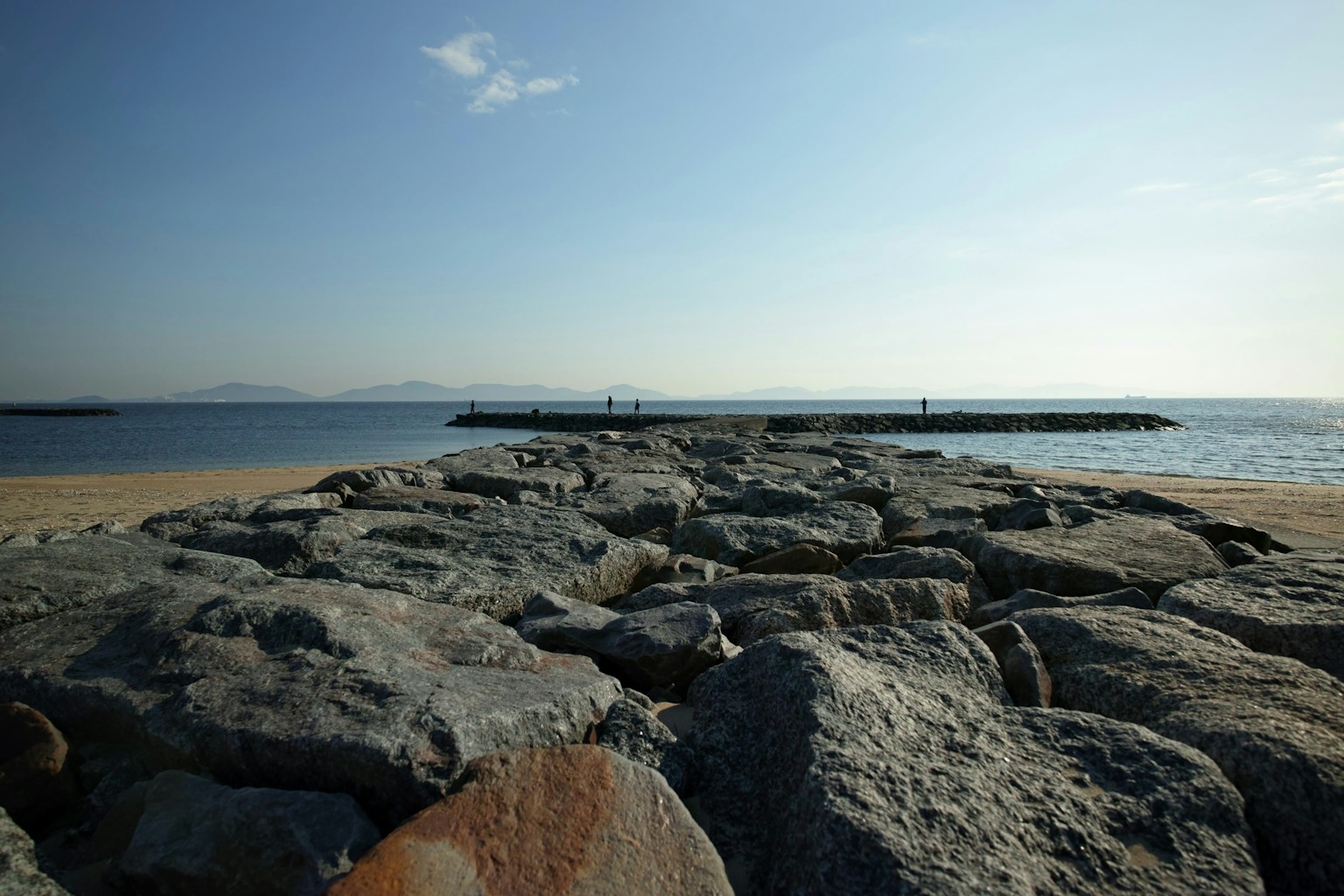 岩で作られた防波堤と青い海の風景
