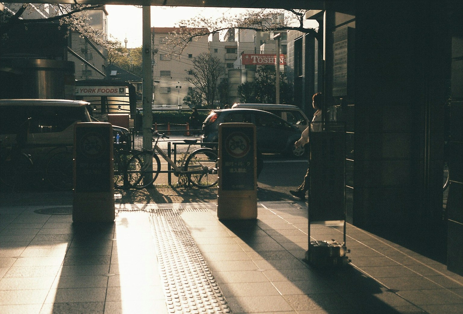 Scena all'ingresso di una stazione con tornelli e biciclette al tramonto