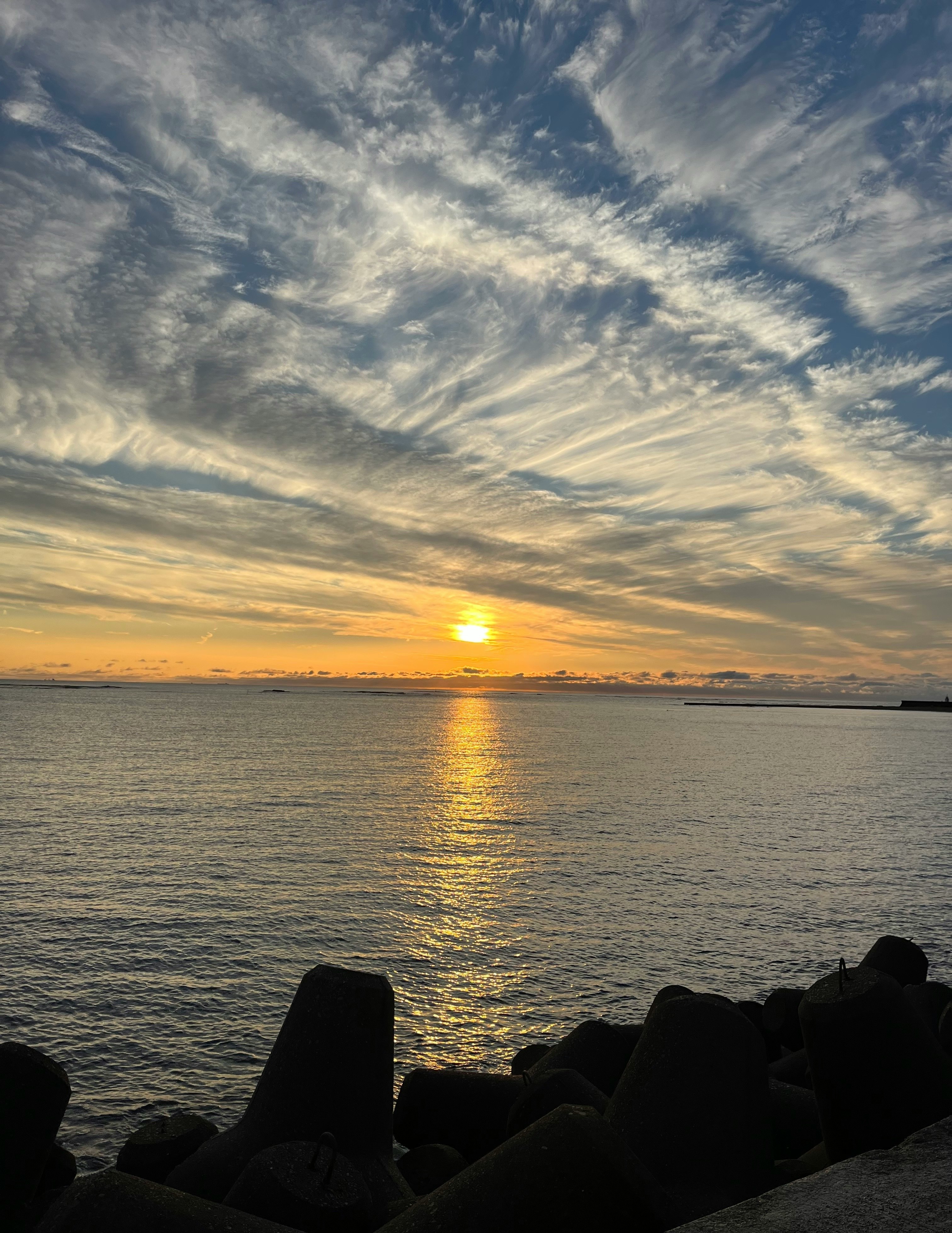 夕日に照らされる海辺の防波堤からの眺め