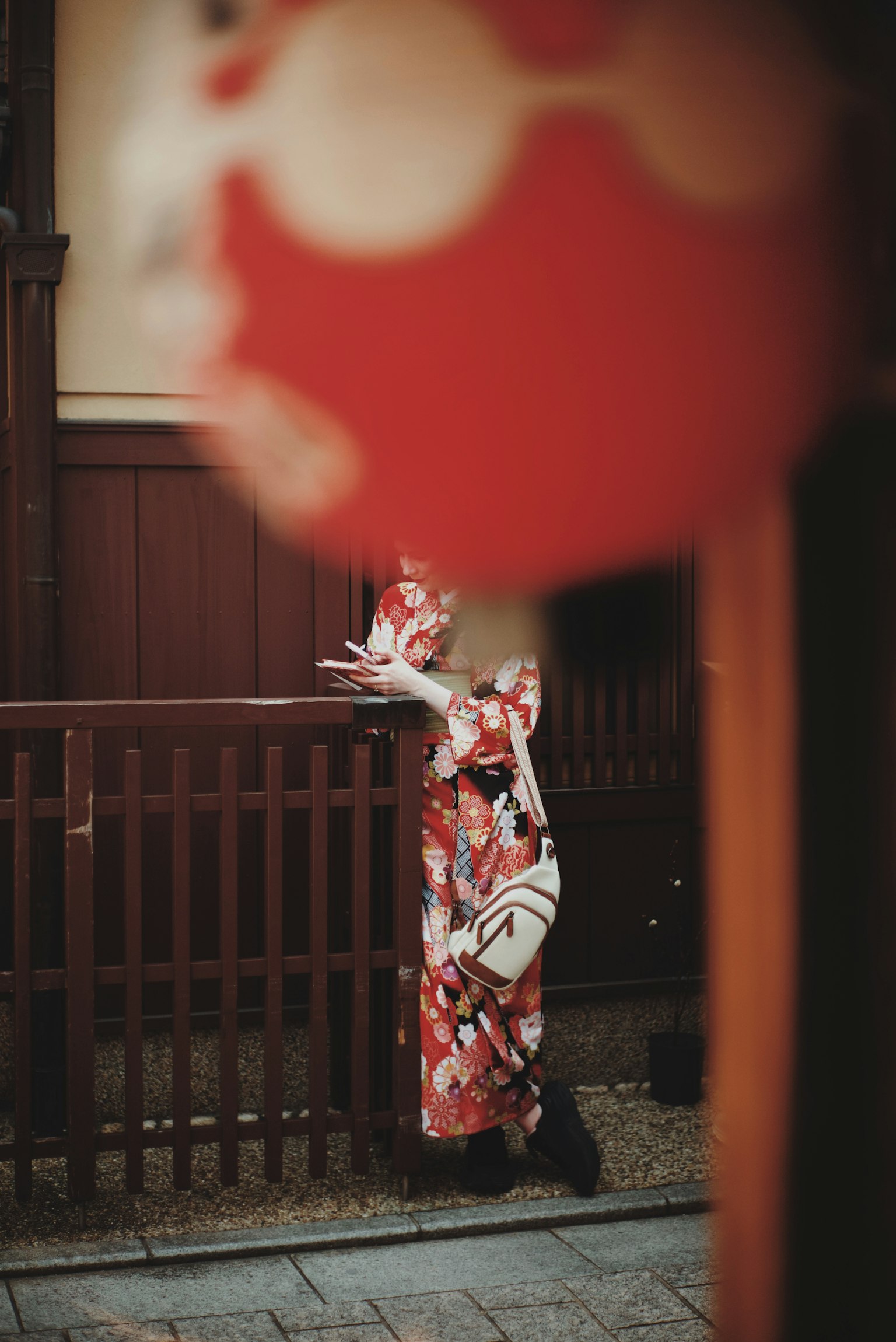 Una mujer en kimono cerca de una linterna roja en un entorno japonés tradicional