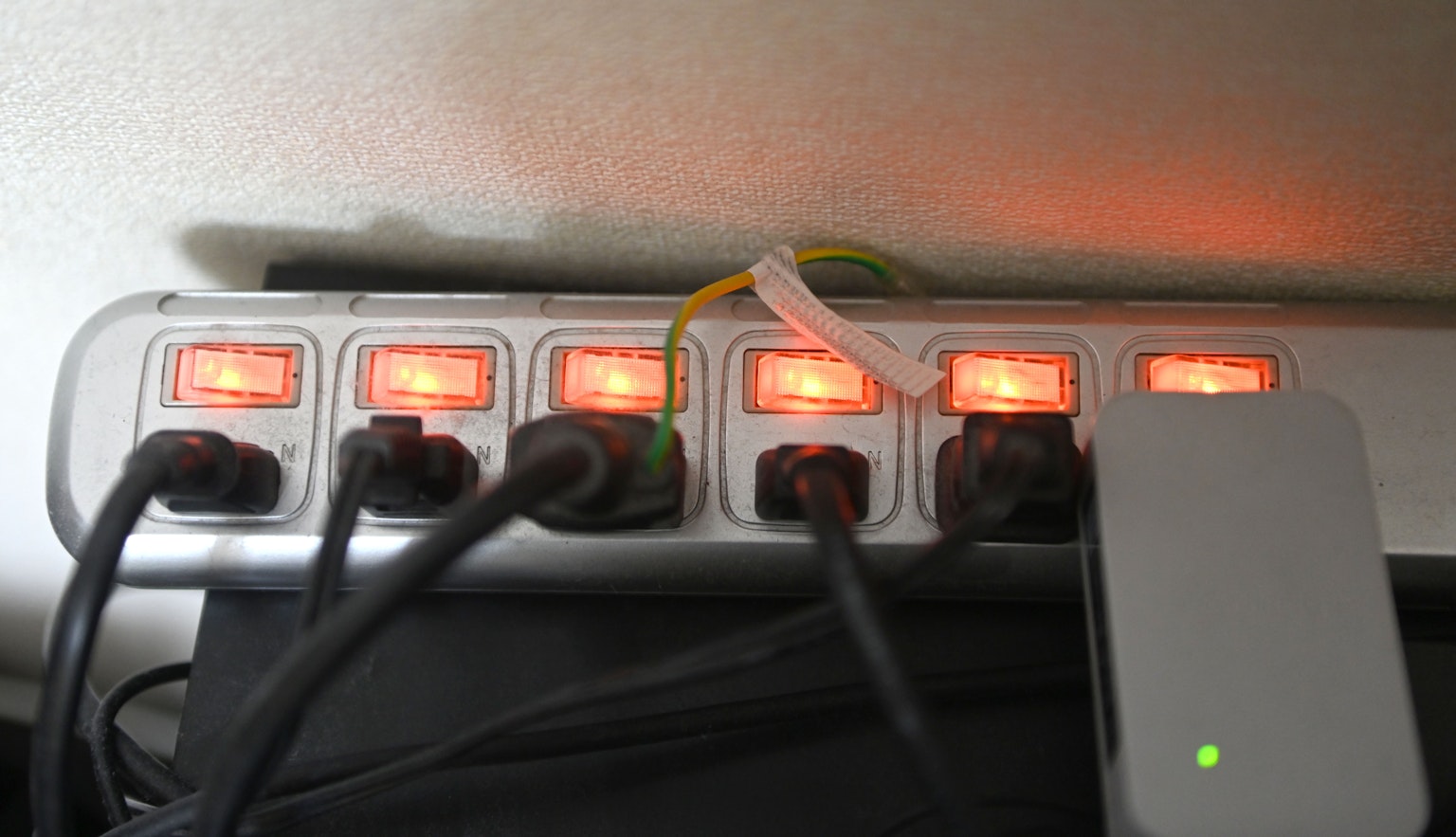 Power strip with multiple plugs connected and lit red indicators