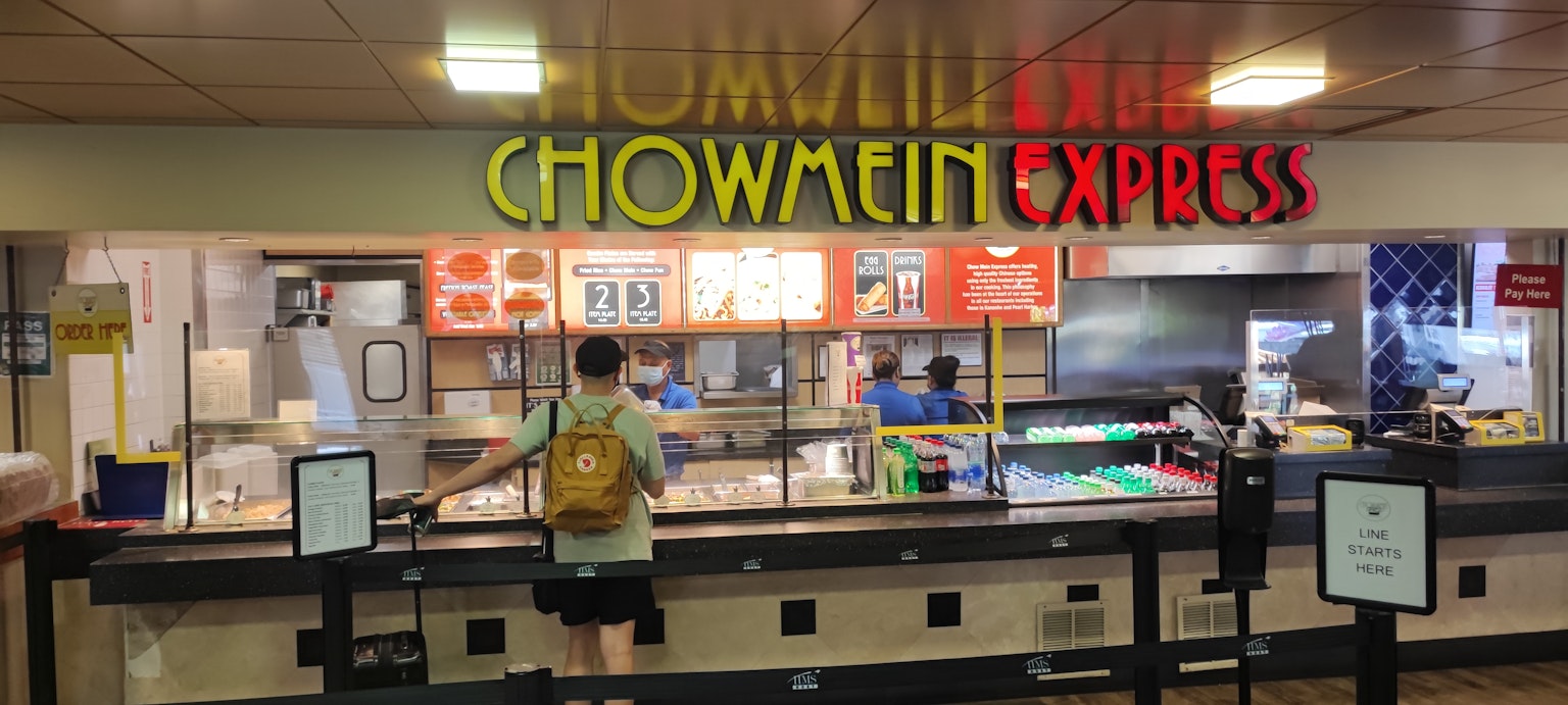 Persona in attesa al bancone di Chowmein Express con insegna colorata
