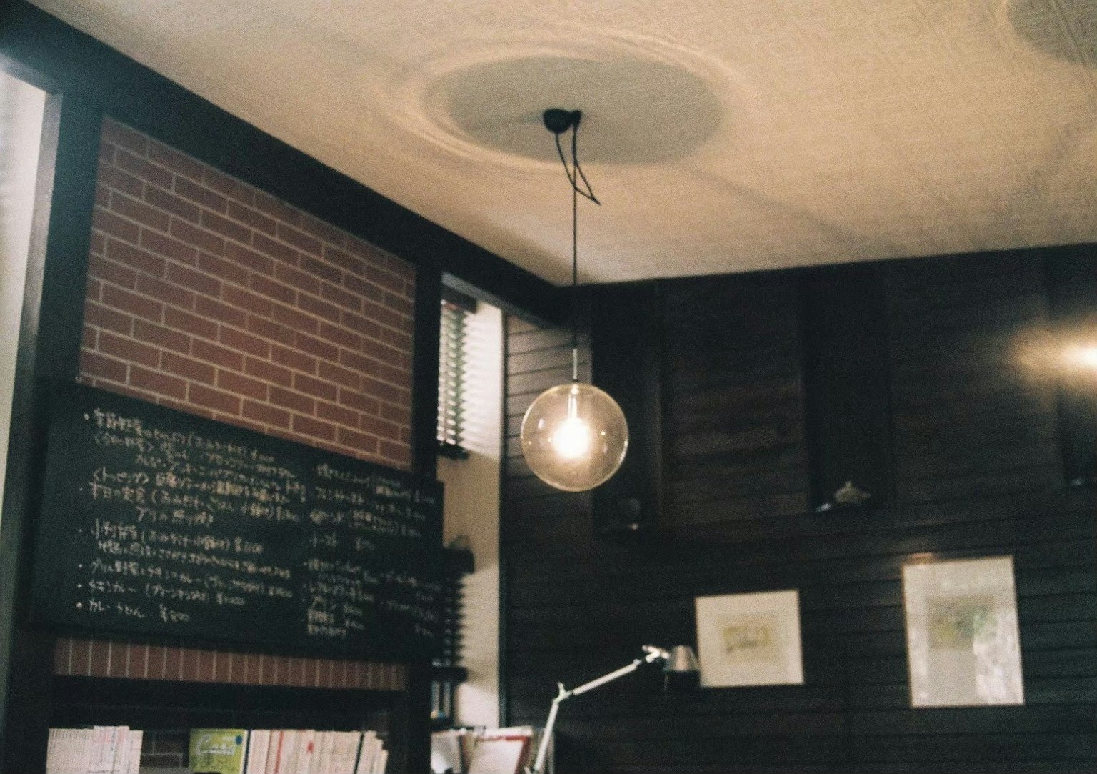 Interior of a cafe featuring a brick wall and simple lighting