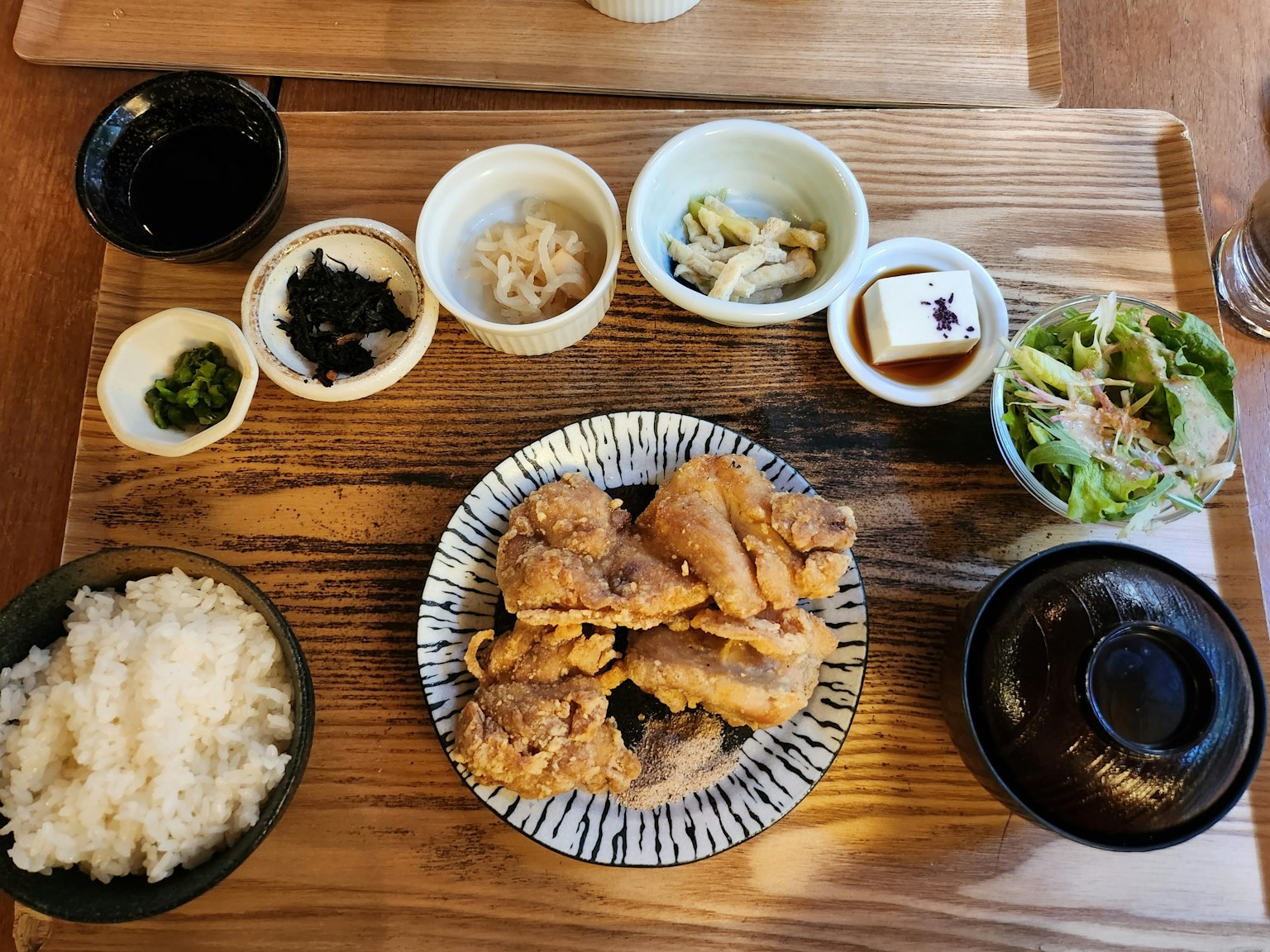 日本定食包含炸鸡米饭沙拉和几道小菜