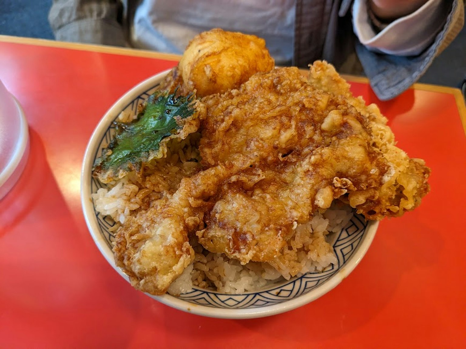 Ciotola di riso con pollo fritto e una foglia verde
