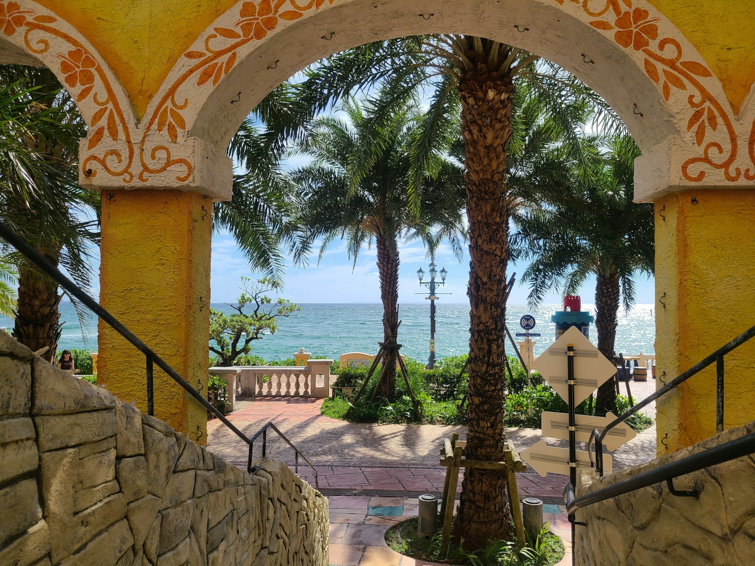 Vue de la mer à travers une arche avec des palmiers