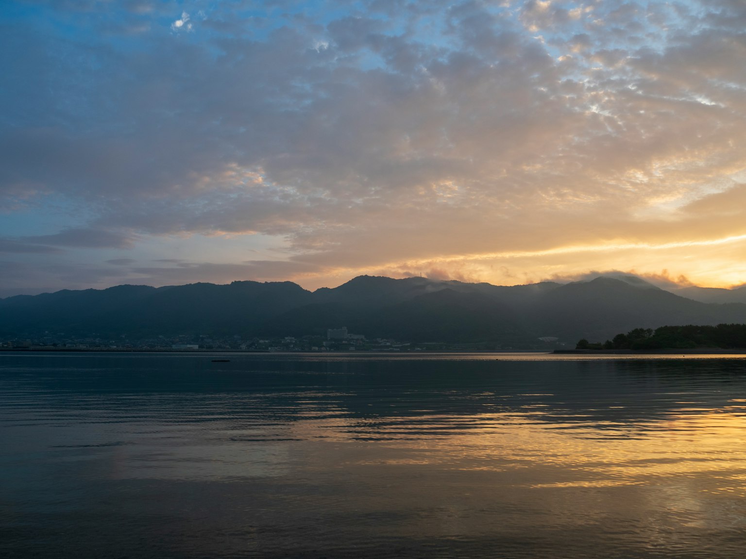 Lago sereno che riflette un bellissimo tramonto e nuvole