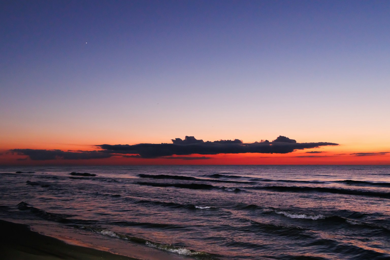 Hermoso atardecer sobre el mar con cielo rojo y púrpura olas tranquilas