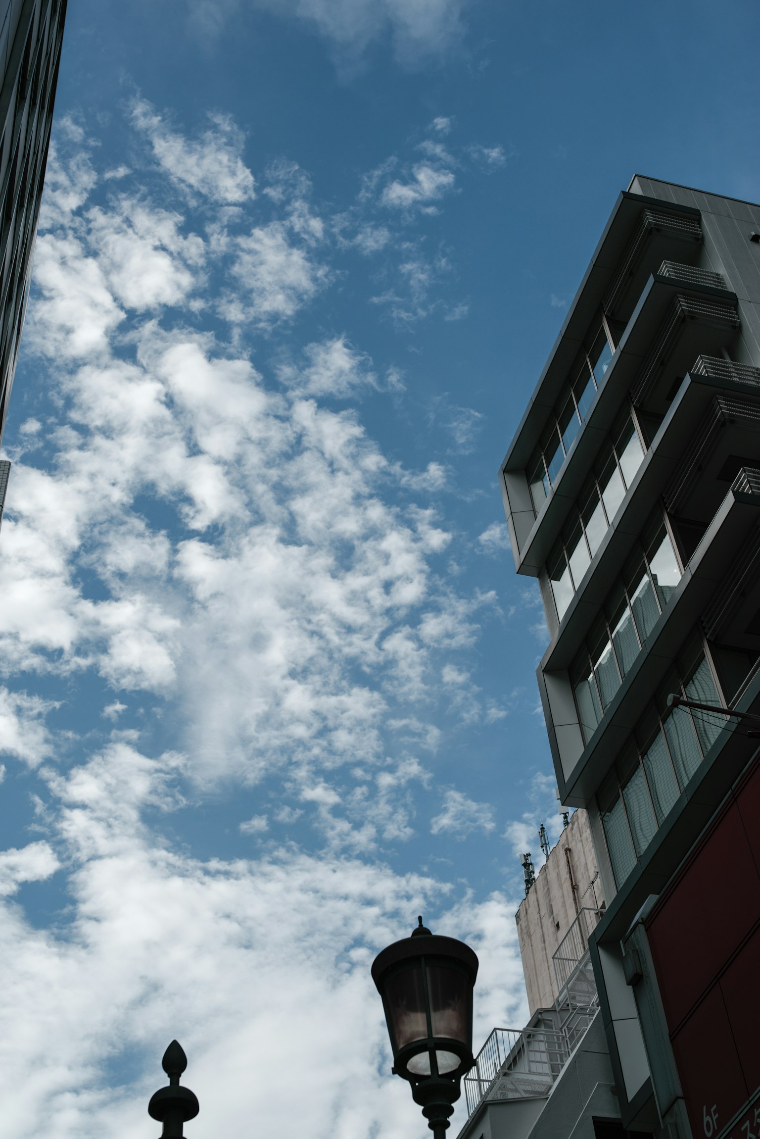 Vue de la ville avec ciel bleu et nuages blancs avec des immeubles et un lampadaire