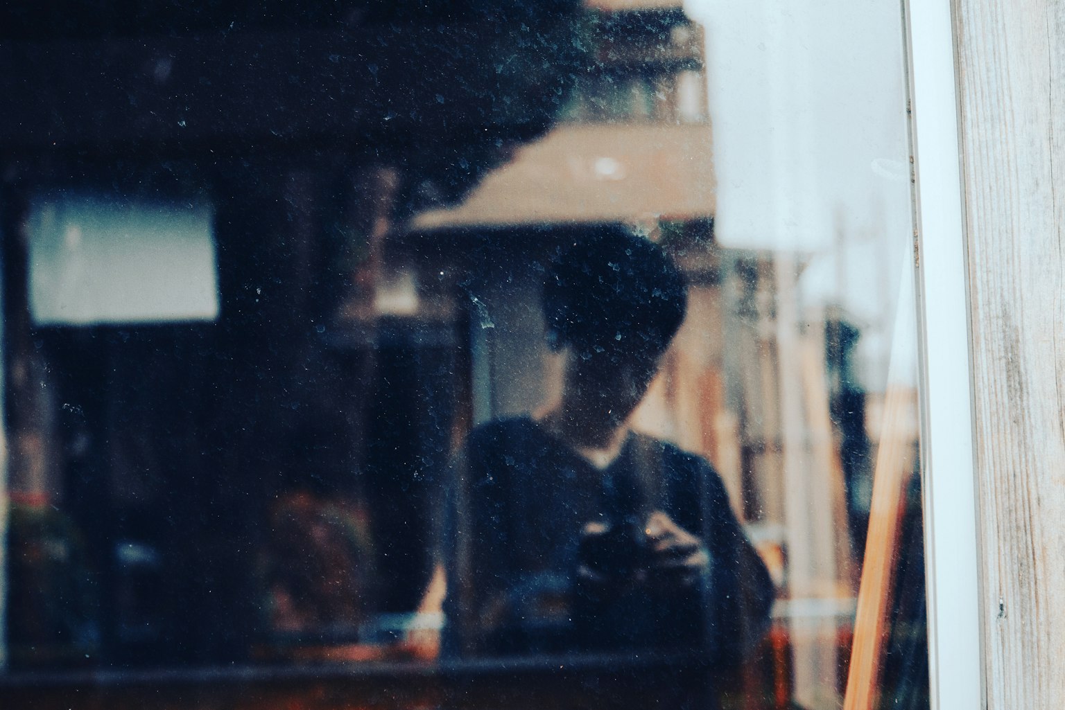 Silhouette of a person reflected in a window with a blurred background