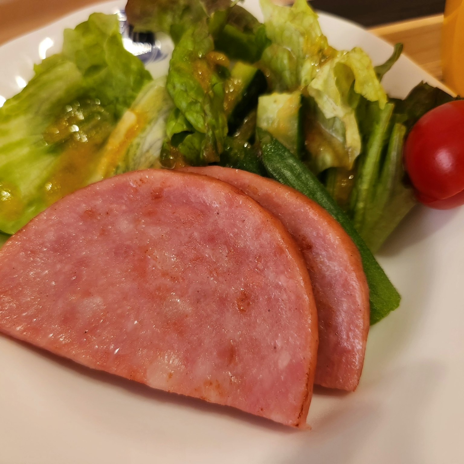 盤子裡有切片火腿和配菜沙拉