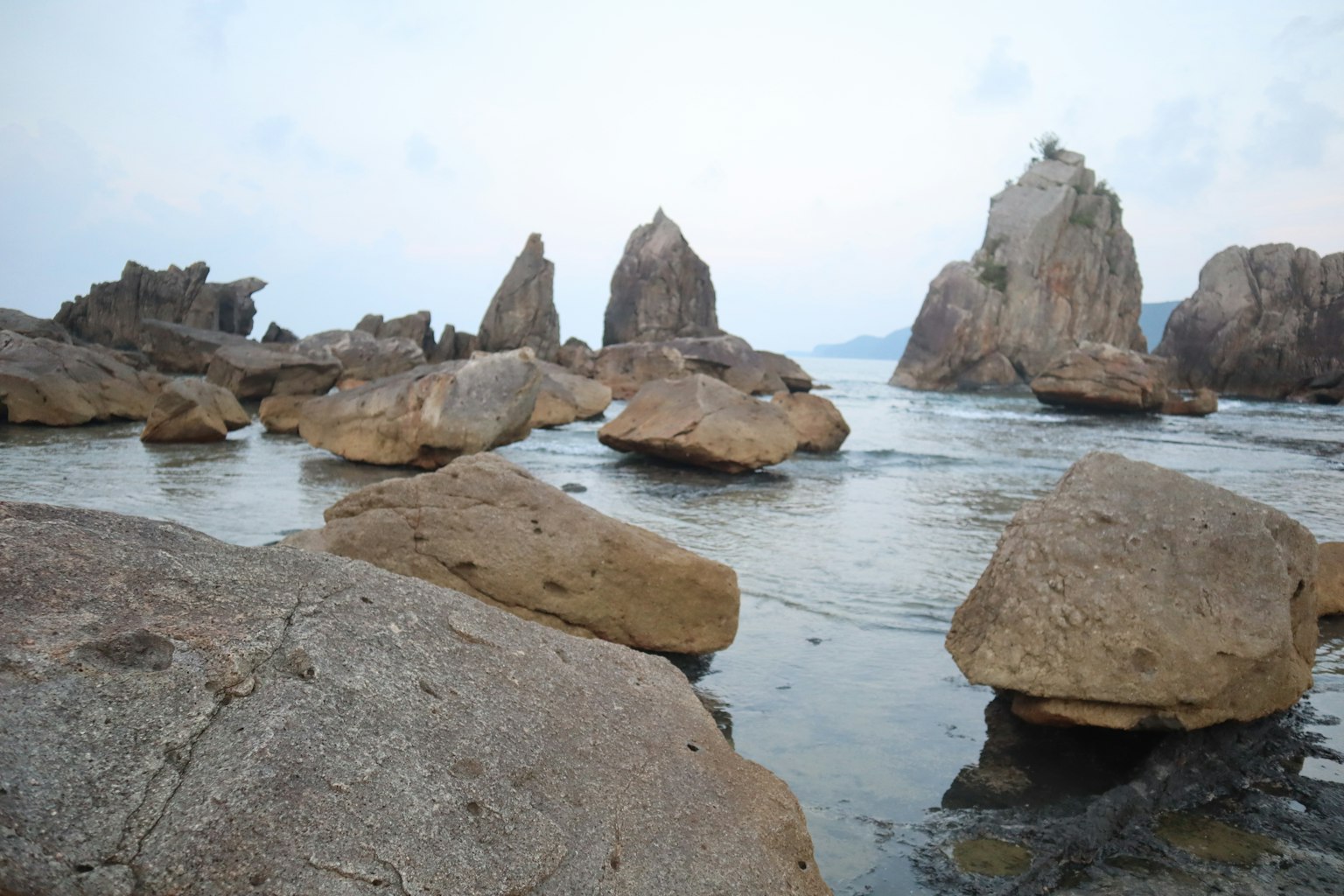 Coastal landscape featuring large rocks and calm water