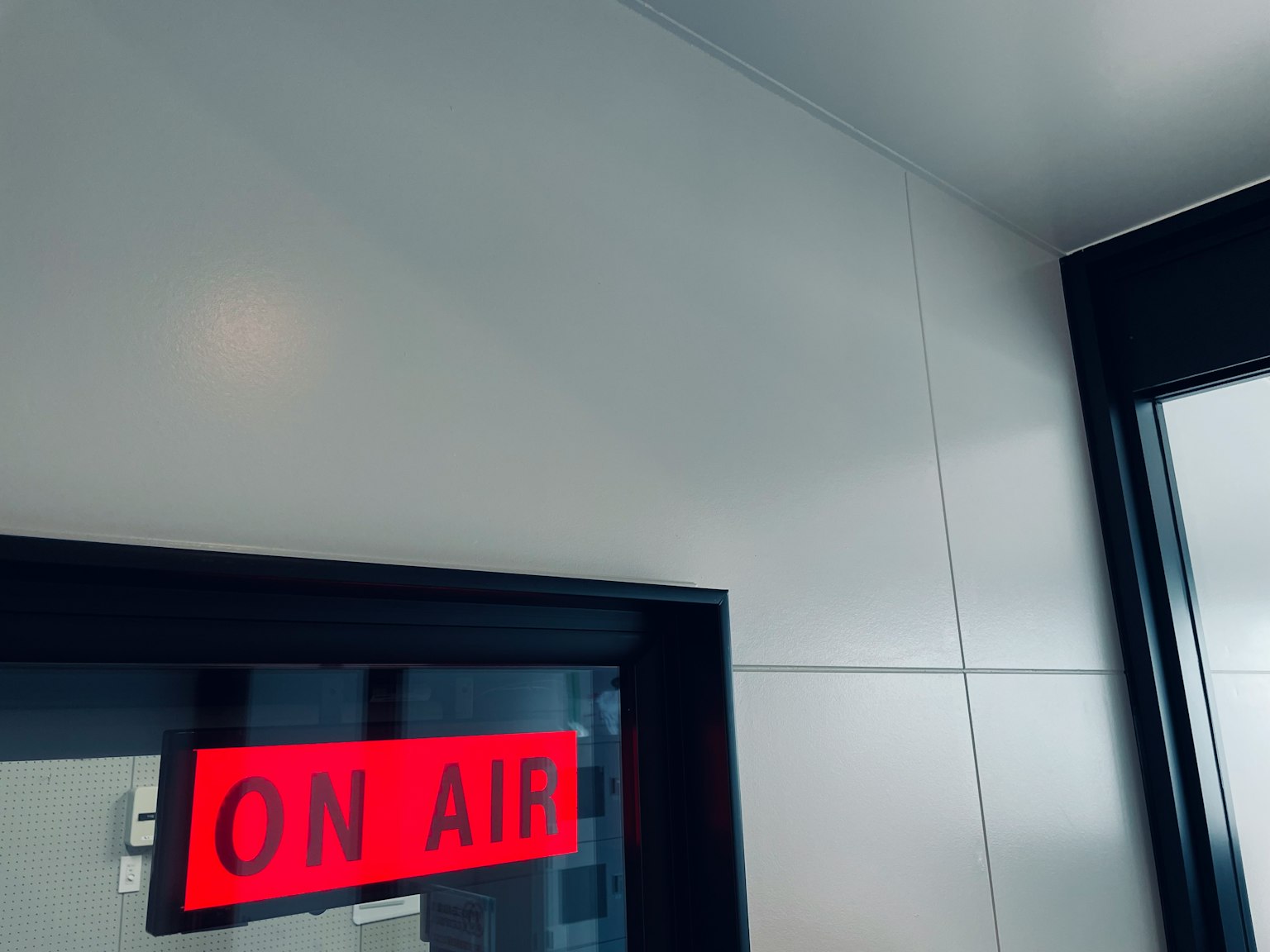 Papan merah 'ON AIR' di pintu masuk studio