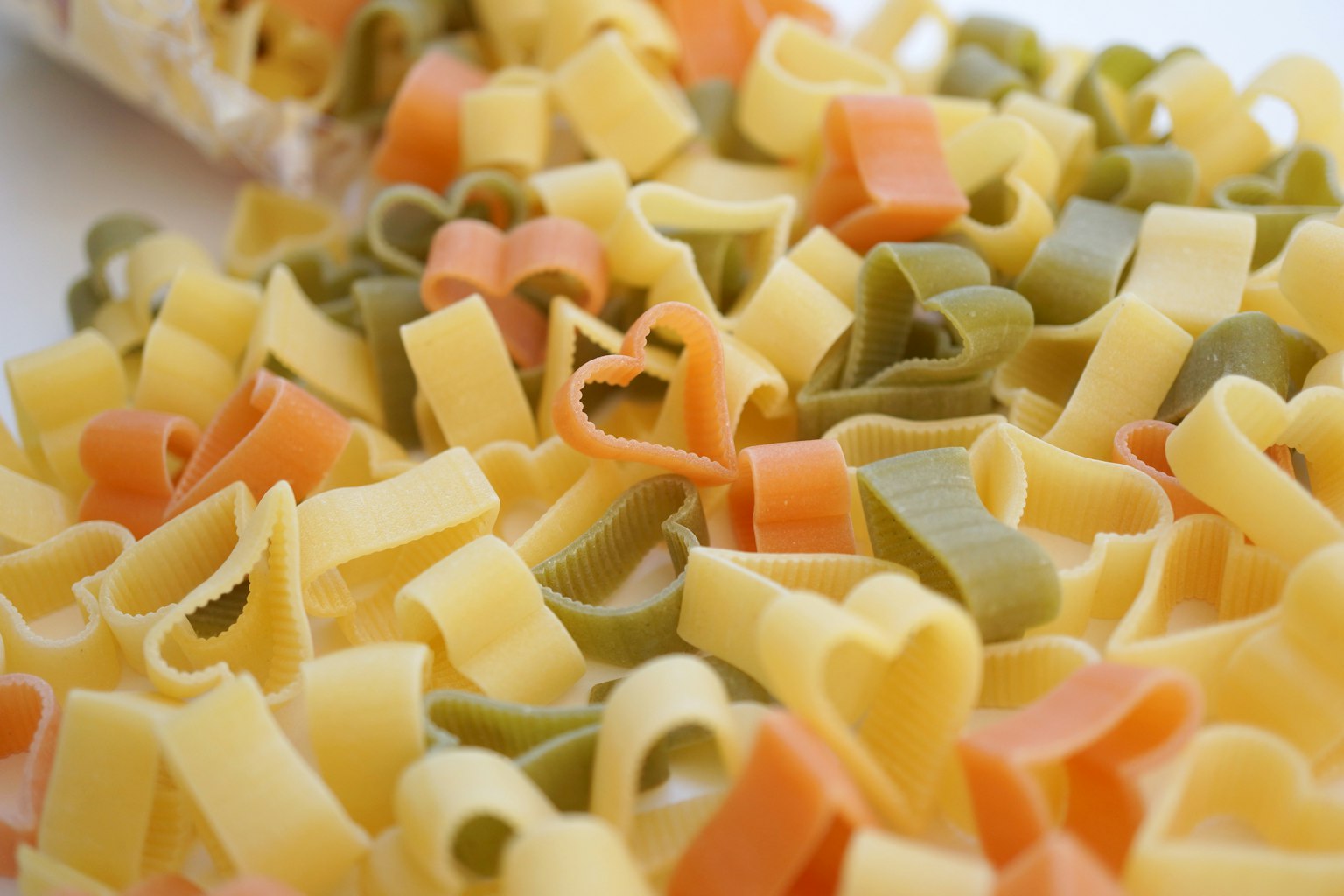 Pasta colorata a forma di cuore mescolata insieme