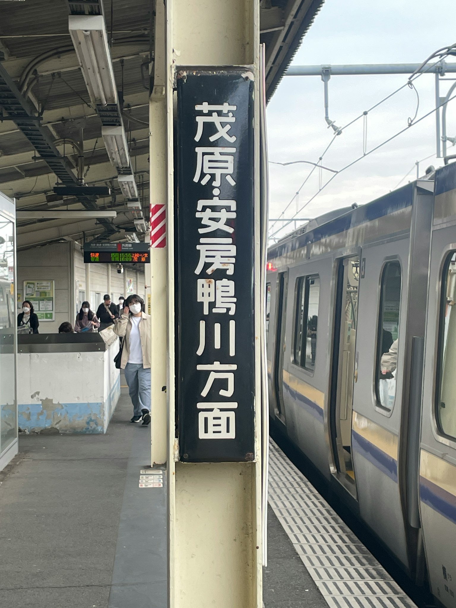 Cartel de estación de tren que indica la prefectura de Ibaraki con tren visible