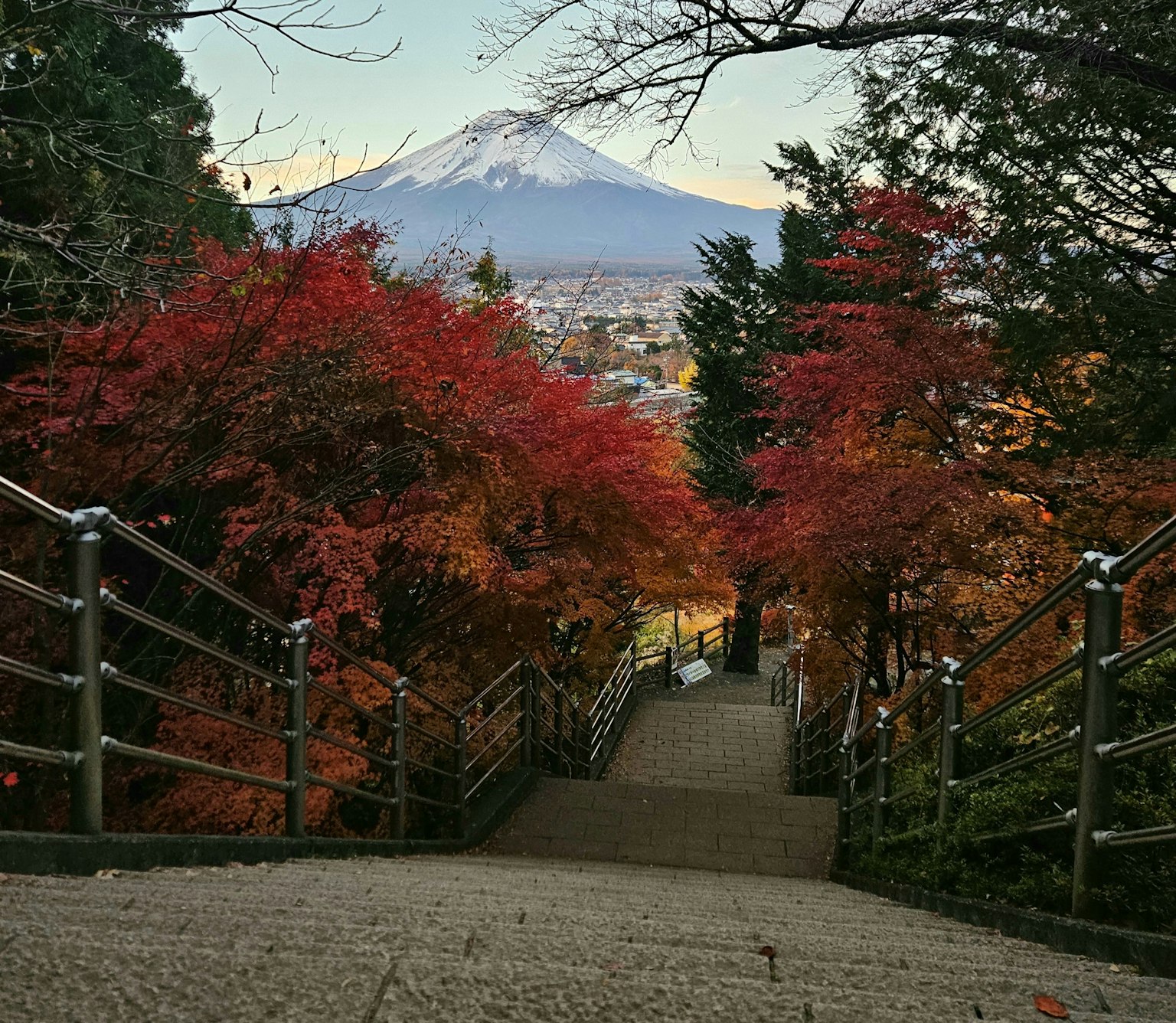 Vista escénica de escaleras rodeadas de follaje otoñal y el monte Fuji al fondo