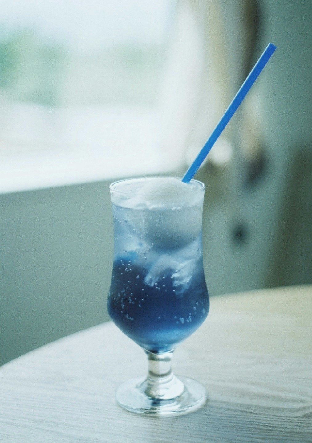 青いカクテルグラスの氷入りドリンク画像
