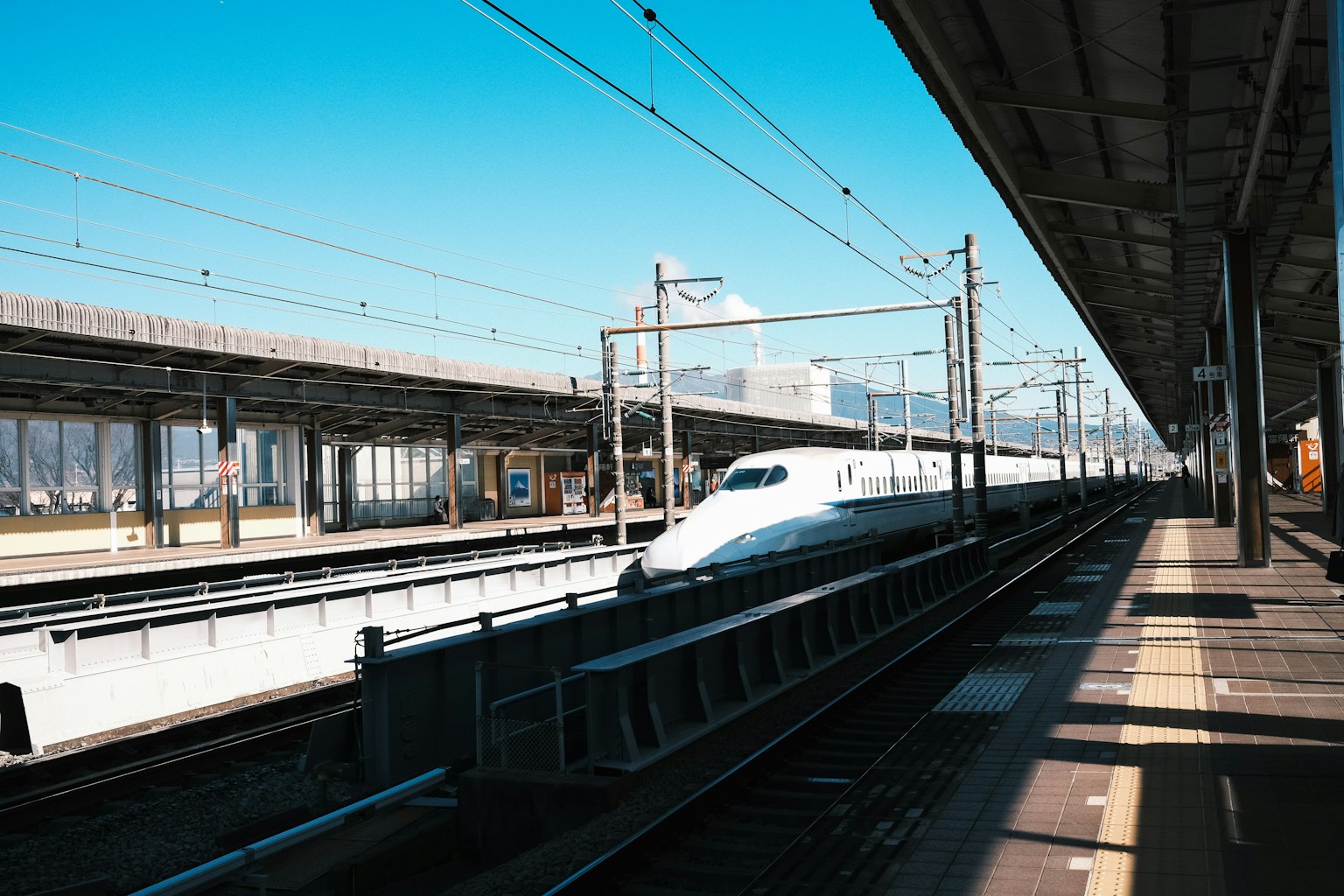 新幹線列車在車站停靠，藍天晴朗