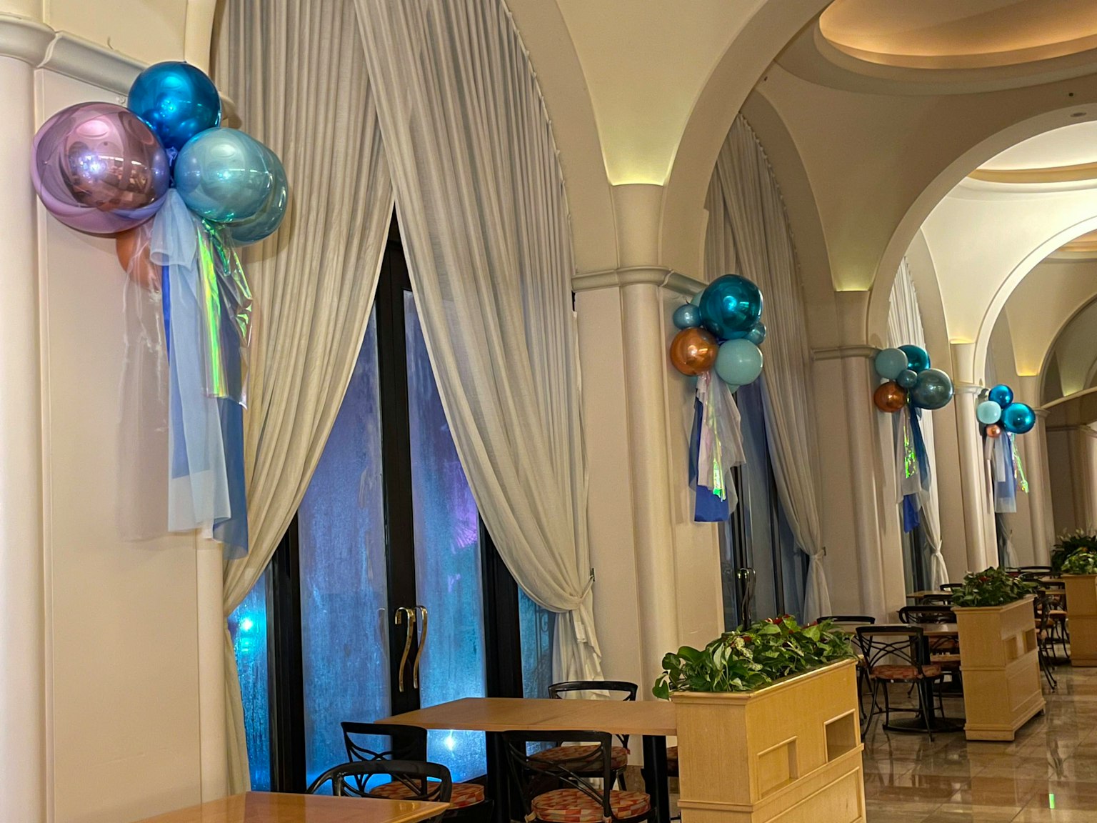 Ruang dalam yang elegan dengan balon biru dan tirai yang dijuntai