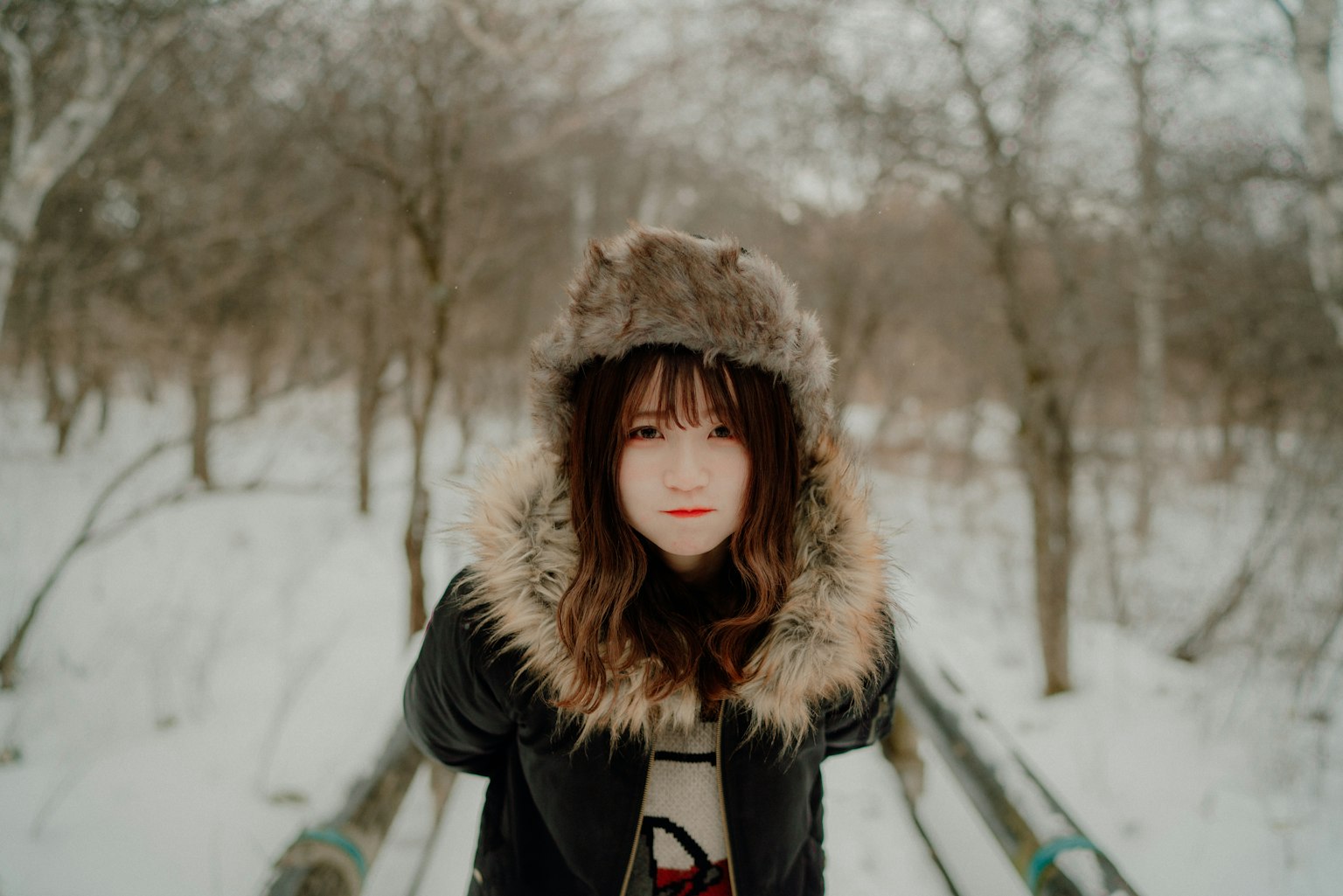 雪地裡戴著毛絨帽子的年輕女性肖像
