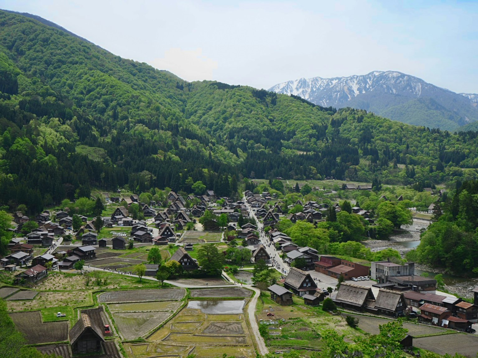 ทิวทัศน์ที่สวยงามของหมู่บ้านญี่ปุ่นดั้งเดิมที่ถูกล้อมรอบด้วยภูเขาสีเขียว