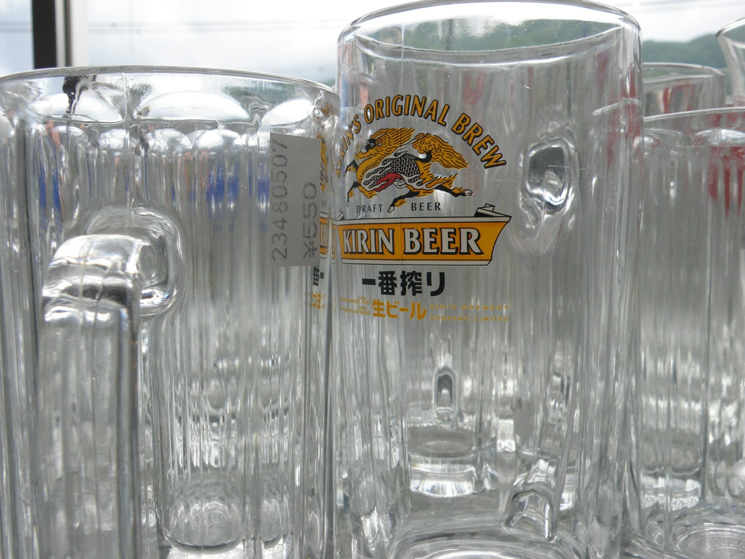 Una collezione di boccali di birra trasparenti con un boccale etichettato che mostra un logo