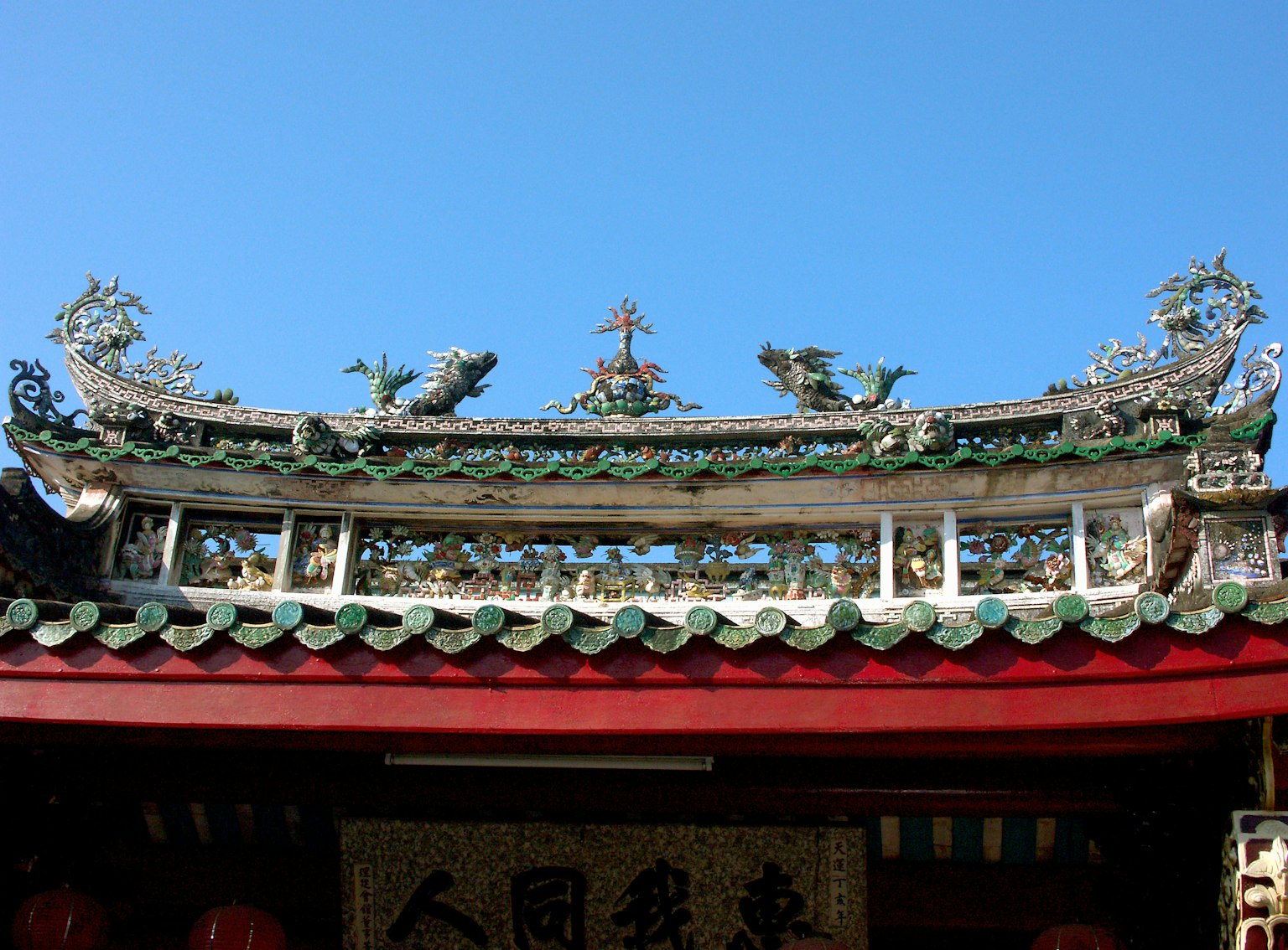 蓝天下的中国寺庙屋顶，装饰性的龙和复杂的瓦片