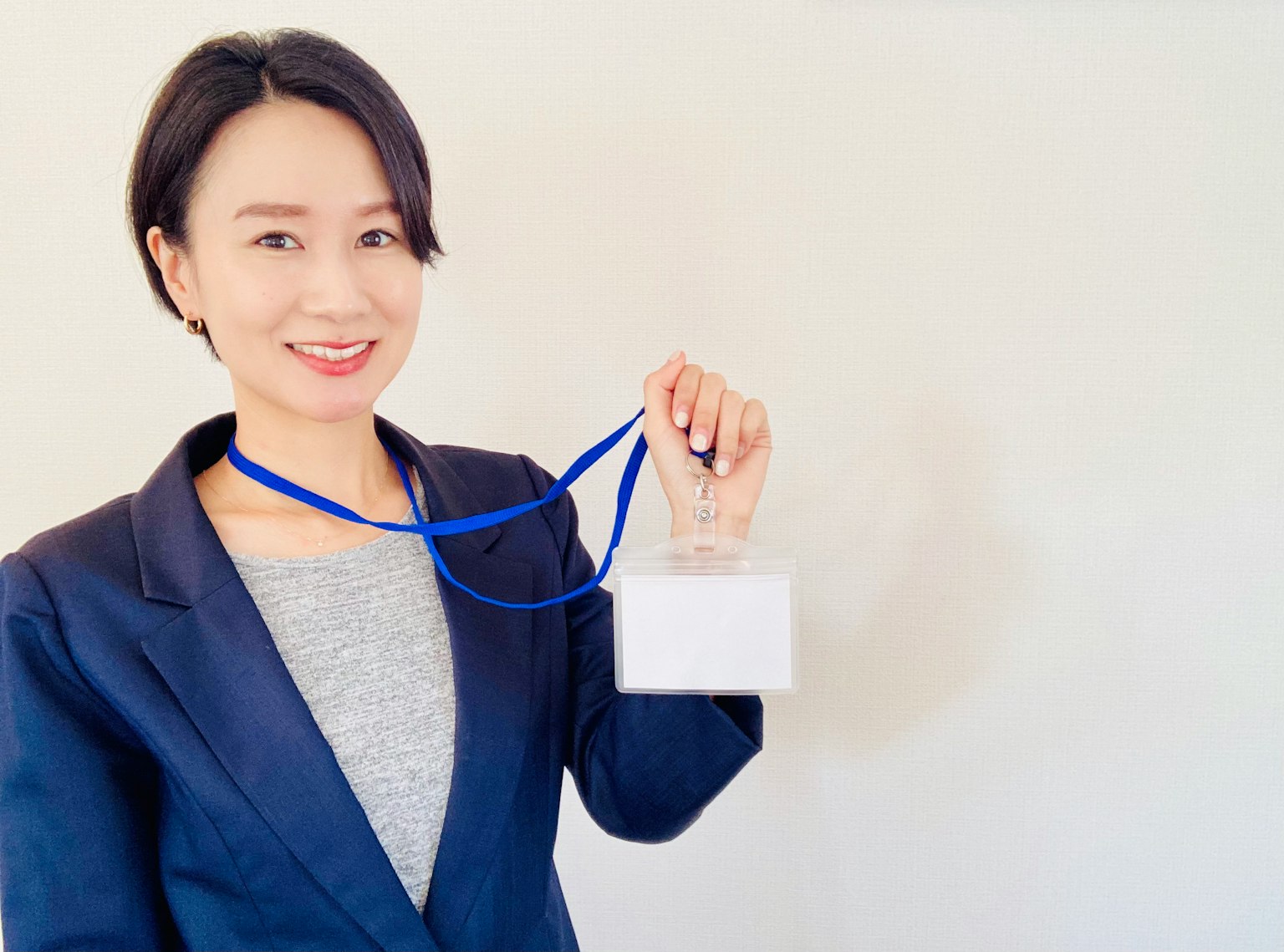 女性手持一座挂着蓝色丝带的奖杯