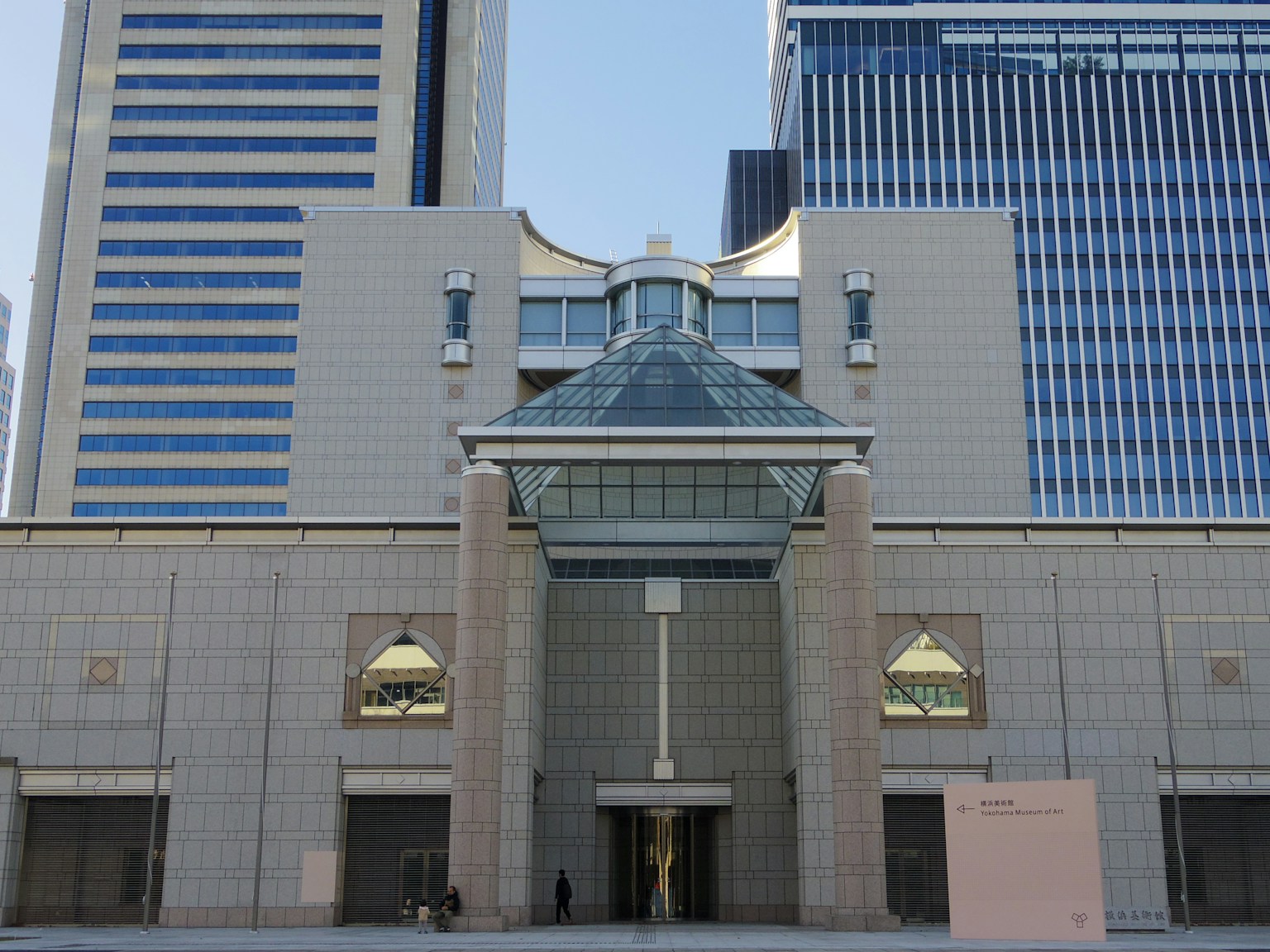 现代建筑外观，带有玻璃屋顶和相邻的摩天大楼