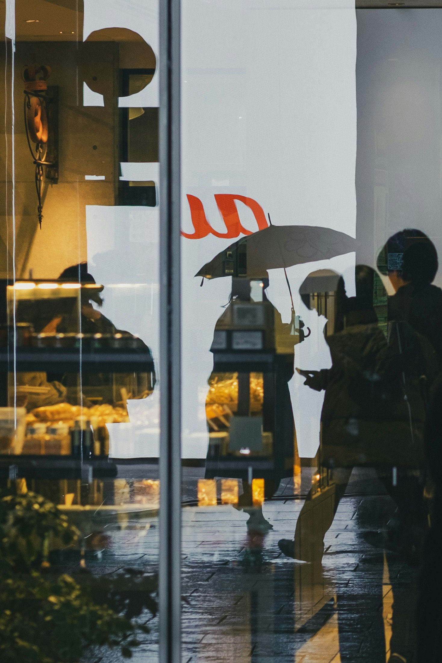 Personensilhouetten durch ein Fenster bei Regen