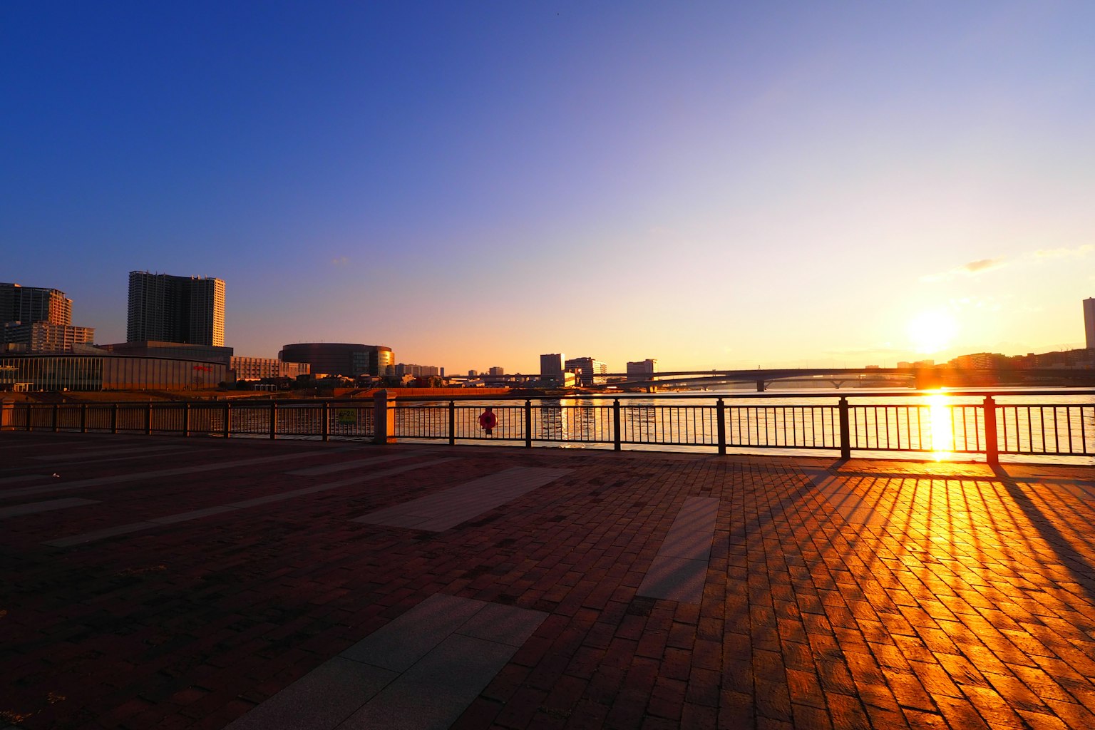 Coucher de soleil se reflétant sur la rivière avec la silhouette de la ville en arrière-plan