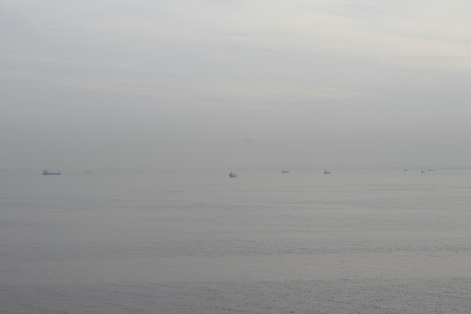 Pemandangan berkabut kapal yang mengapung di laut tenang