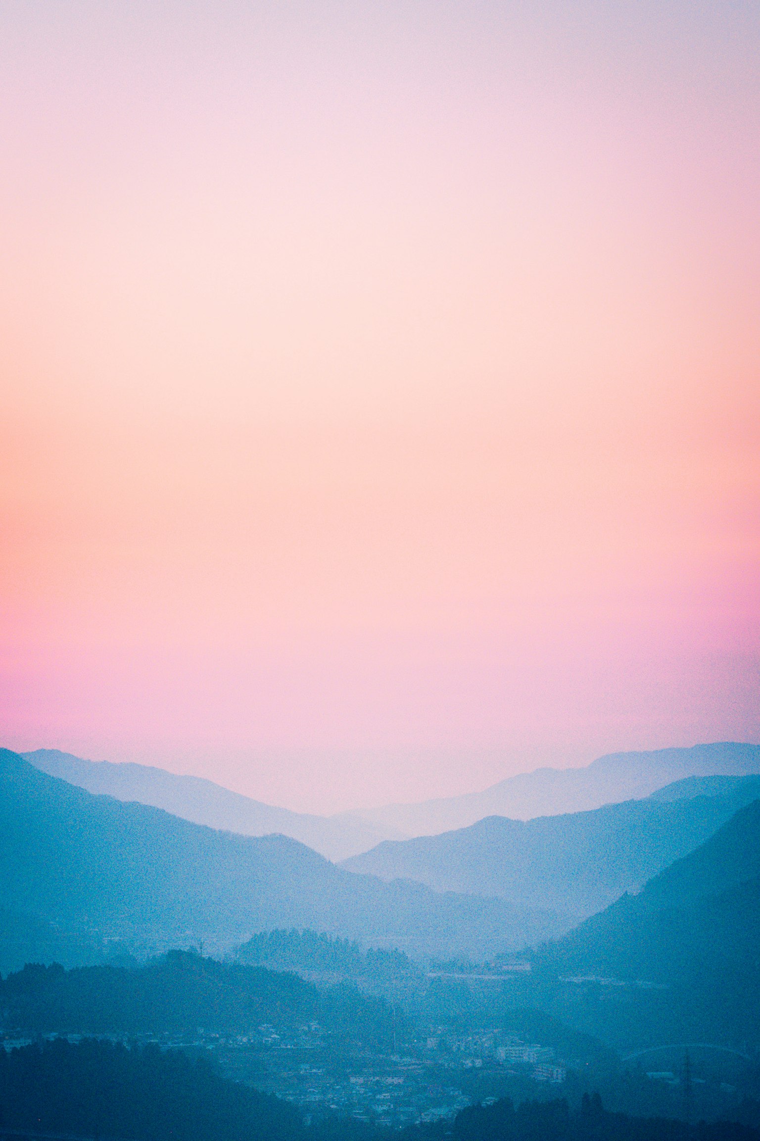 Paesaggio montano circondato da un cielo sfumato di blu e rosa