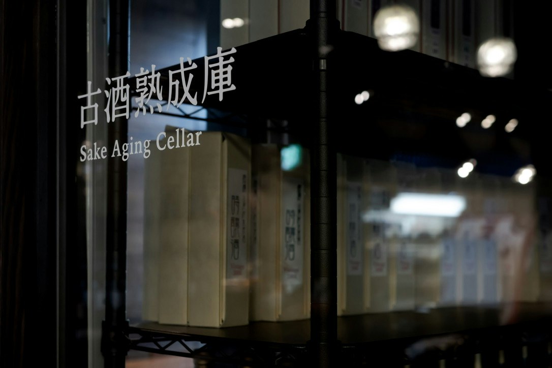 昏暗清酒熟成地窖的招牌与酒桶画面