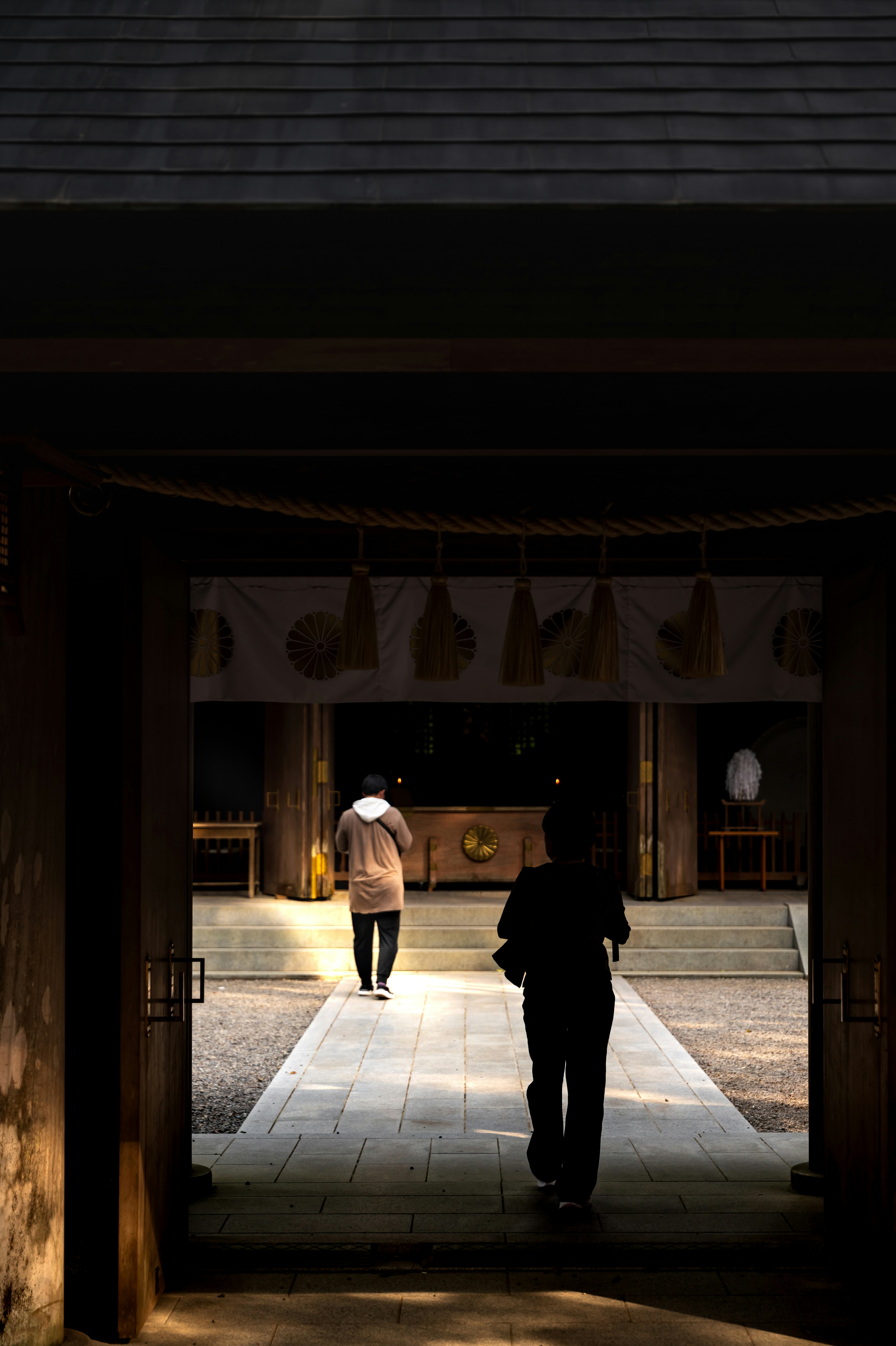 ingresso del cancello di un tempio con vialetto illuminato da lanterne al crepuscolo